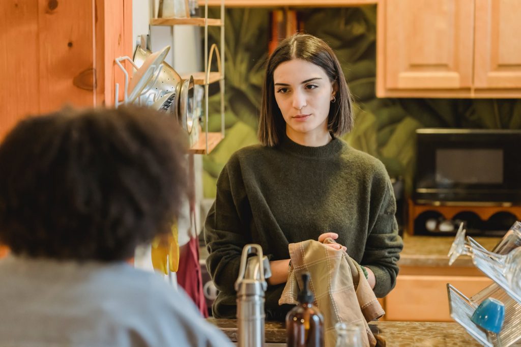 young women talking in modern interior of kitchen